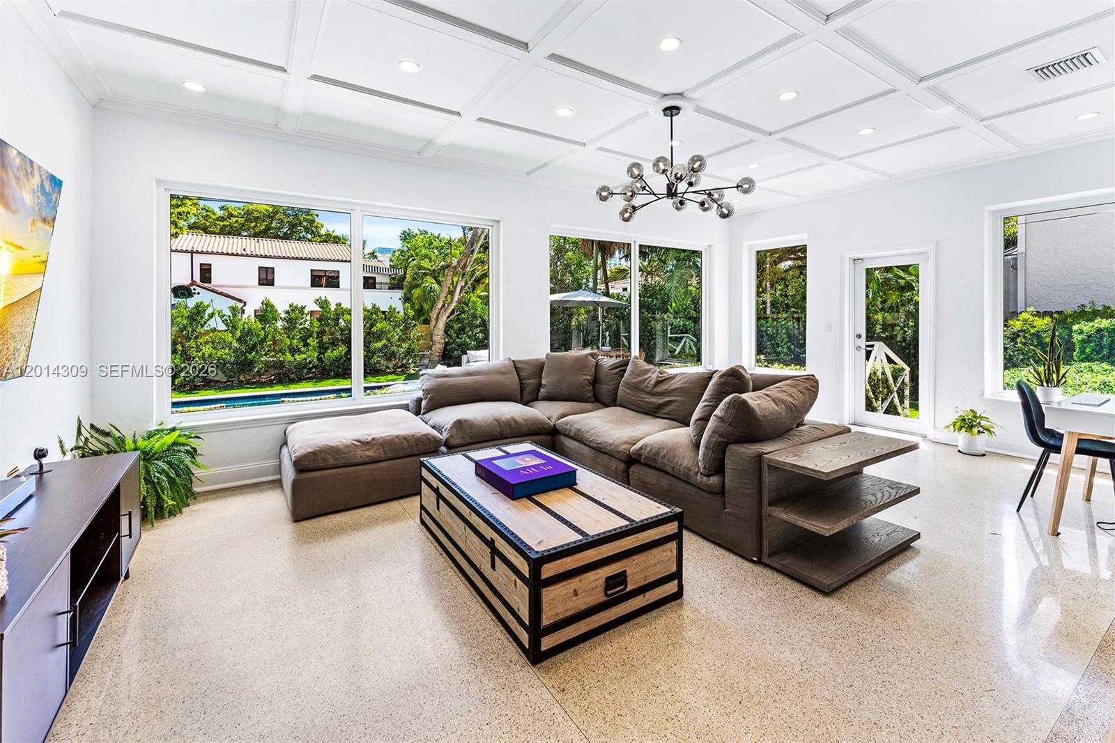 A bright living room features a large sectional sofa, a trunk coffee table, and coffered ceilings — 6145 La Gorce Dr, Miami Beach FL 33140, MIAMI BEACH, FL