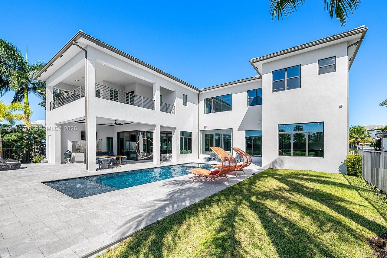 A two-story modern house features a swimming pool, patio, and a grassy backyard — 17187 Brulee Breeze Way, Boca Raton FL 33496, BOCA RATON, FL