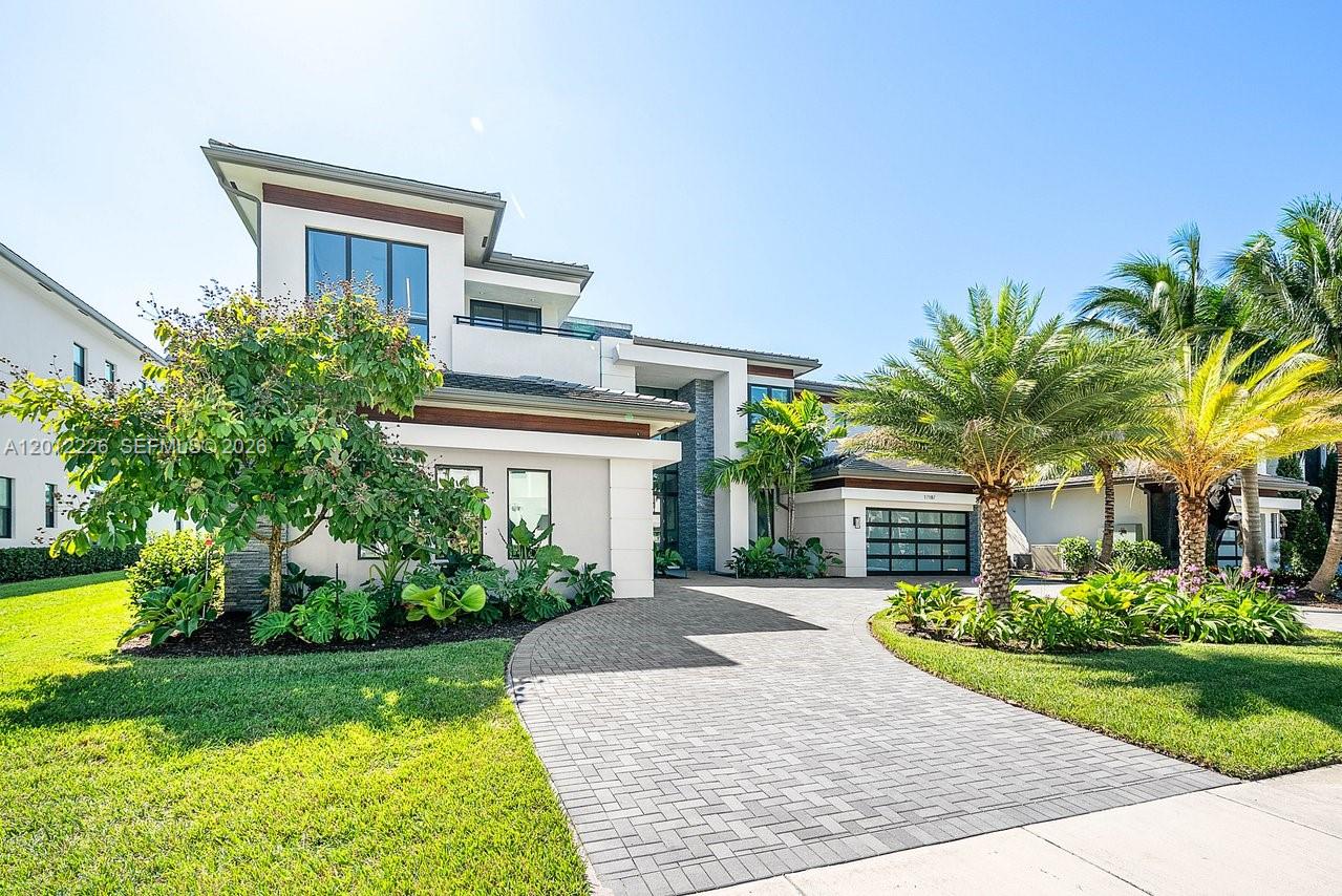 A modern two-story house with a paved driveway, lush landscaping, and a multi-car garage — 17187 Brulee Breeze Way, Boca Raton FL 33496, BOCA RATON, FL