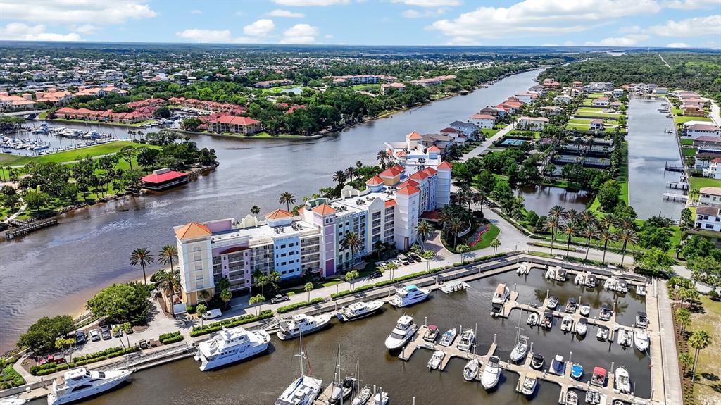 An aerial view shows a large waterfront hotel complex with an adjacent marina and boats — 102 YACHT HARBOR DRIVE UNIT 378, PALM COAST, FL