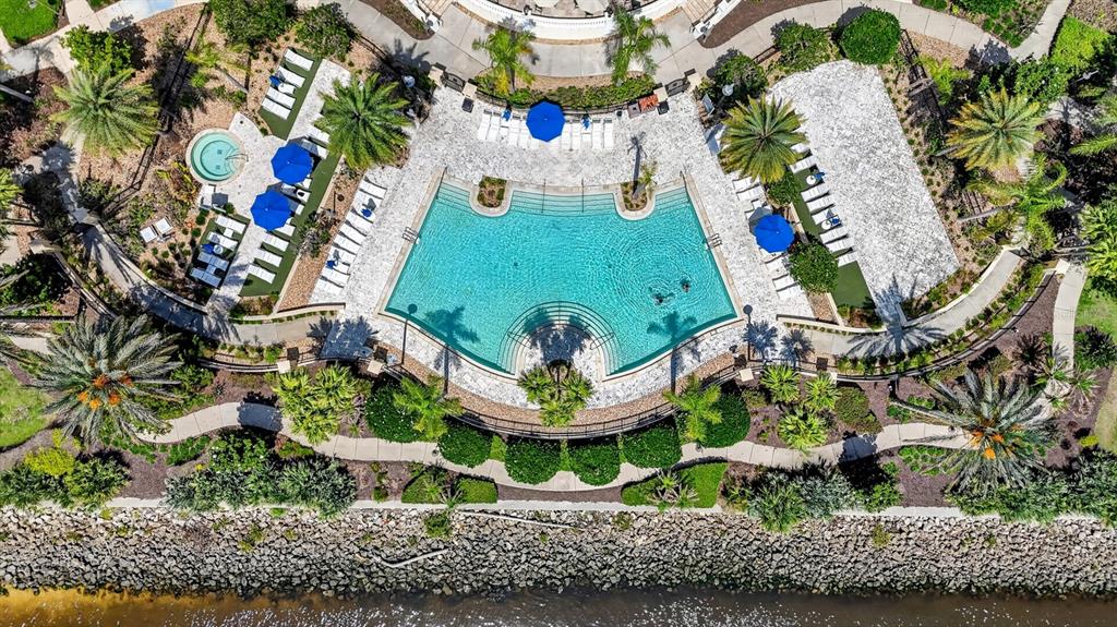 An aerial view of a swimming pool with lounge chairs and palm trees near water — 102 YACHT HARBOR DRIVE UNIT 378, PALM COAST, FL