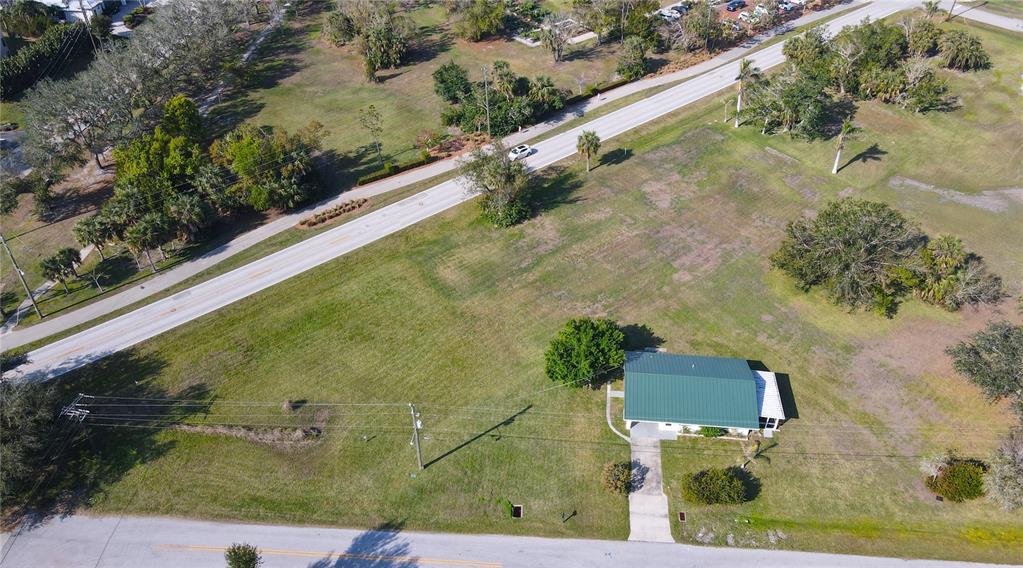 An aerial view shows a house with a green metal roof on a large grassy lot — 590 SHREVE STREET, PUNTA GORDA, FL