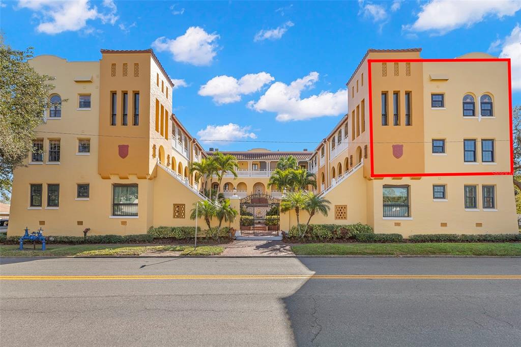 Exterior view of a multi-story yellow apartment building with a red-outlined section on the right — 210 22ND AVENUE NE UNIT 15, ST PETERSBURG, FL