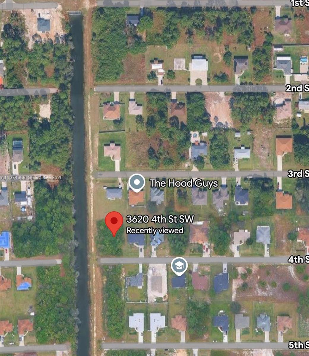 This is a satellite map view showing residential lots and a canal in a neighborhood — 3620 4TH ST SW, Lehigh Acres FL 33976, LEHIGH ACRES, FL