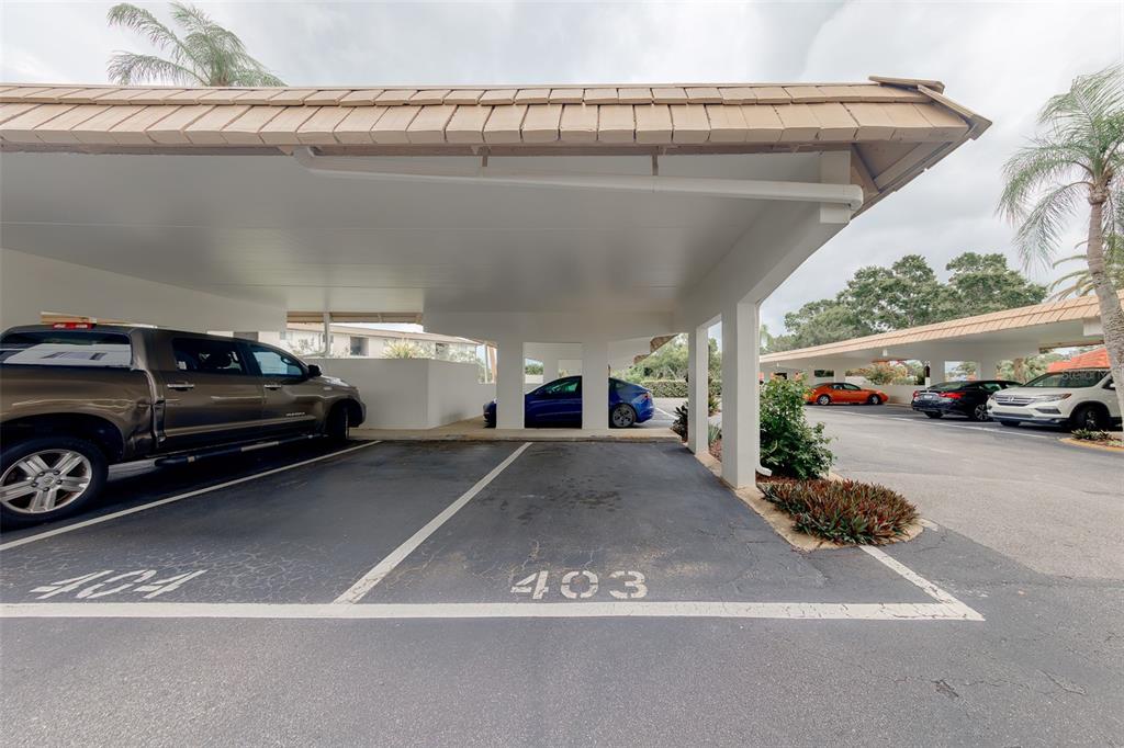A covered parking area features numbered spaces and several parked vehicles — 19029 US HIGHWAY 19 N UNIT 9-403, CLEARWATER, FL