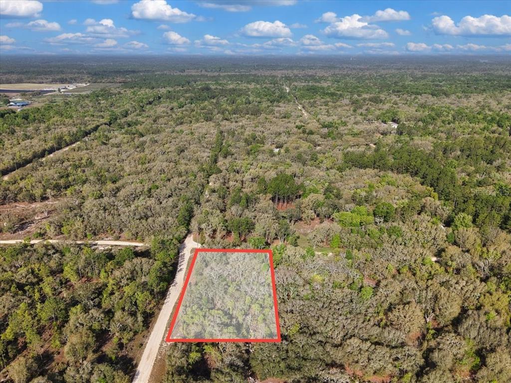 An aerial view shows a rectangular plot of land outlined in red near a road — Lot 362 NE 82ND PLACE, BRONSON, FL