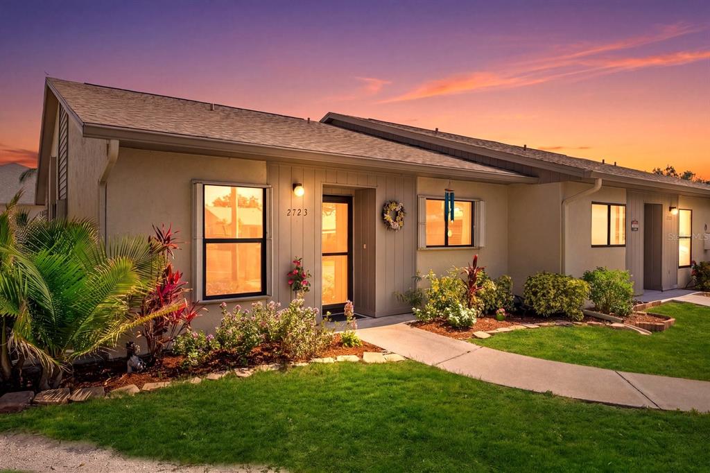 A kitchen with wood cabinets, granite countertops, stainless steel appliances, and a pass-through window — 2723 60TH AVENUE DRIVE W UNIT 2723, BRADENTON, FL
