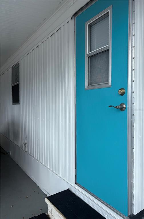 A bright blue exterior door with a window sits on the side of a home — 8300 SEMINOLE BOULEVARD UNIT 229, SEMINOLE, FL