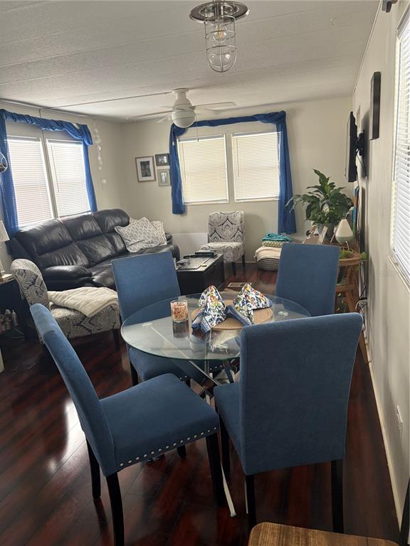 A living and dining area features a glass table, blue chairs, and a leather sofa — 8300 SEMINOLE BOULEVARD UNIT 229, SEMINOLE, FL