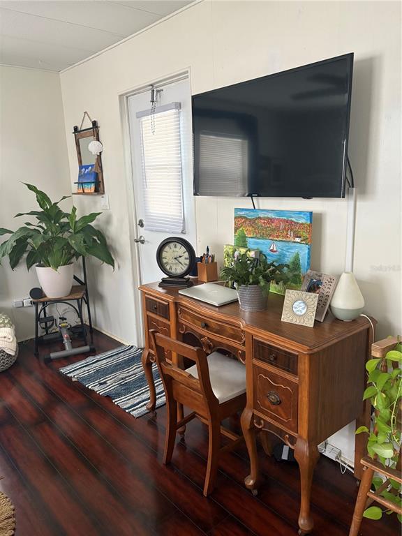 A room features a wooden desk, a wall-mounted television, and a potted plant — 8300 SEMINOLE BOULEVARD UNIT 229, SEMINOLE, FL