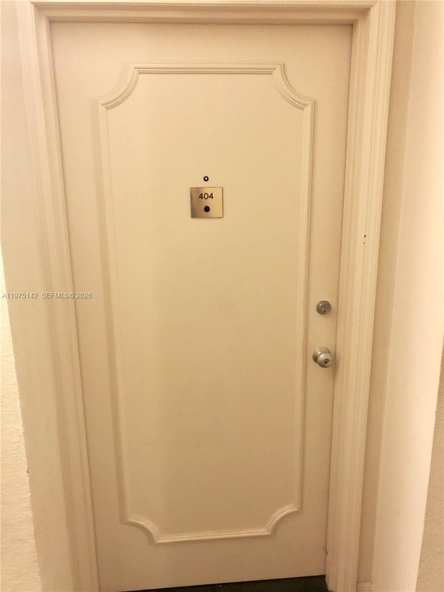 A white door with a silver number 404 plate and a peephole — 1408 Brickell Bay Dr # 404, Miami FL 33131, MIAMI, FL