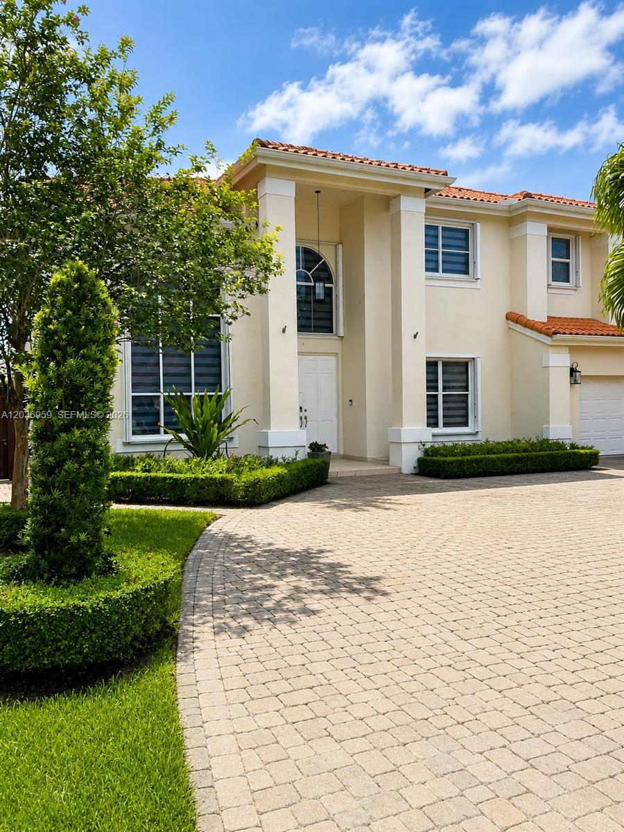 A modern white kitchen features a central island, stainless steel appliances, and glass pendant lights — 4221 SW 154th Pl, Miami FL 33185, MIAMI, FL