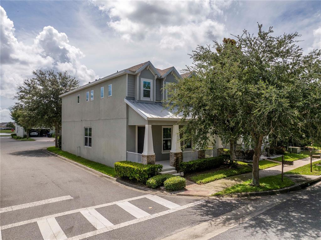 A two-story house with a metal roof, front porch, and stucco exterior sits on a corner — 8225 BRYCE CANYON AVENUE, WINDERMERE, FL