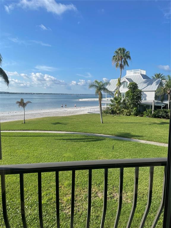A view from a balcony overlooking a grassy lawn, a sandy beach, and the ocean — 895 S GULFVIEW BOULEVARD UNIT 202, CLEARWATER, FL