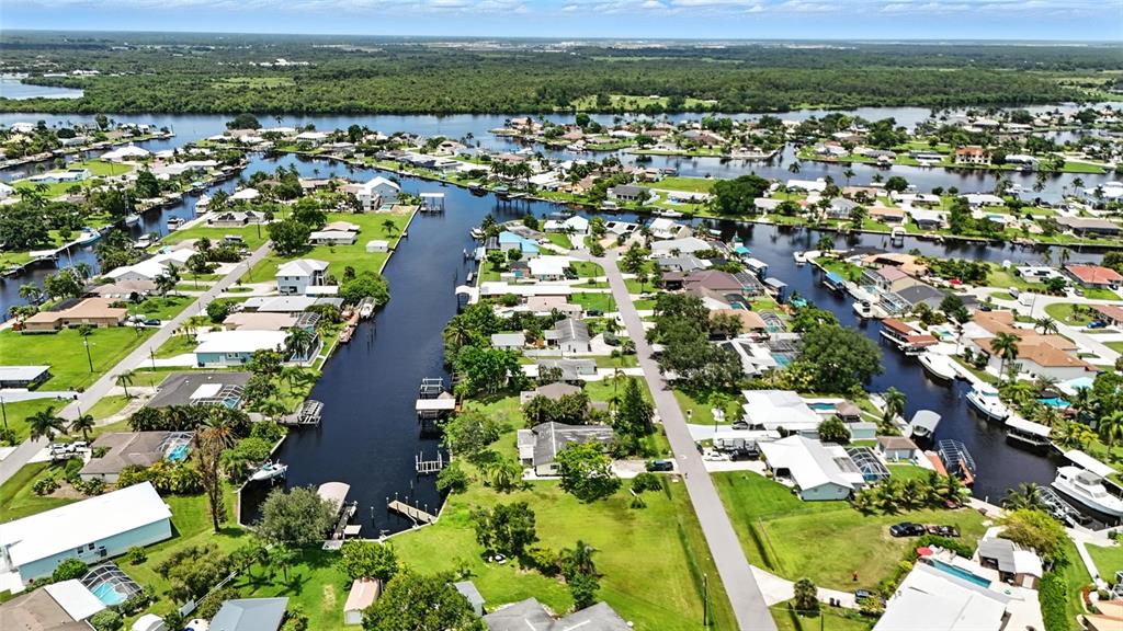An aerial view shows residential houses along a canal system with private boat docks — 2131 SAINT CROIX AVENUE, FORT MYERS, FL