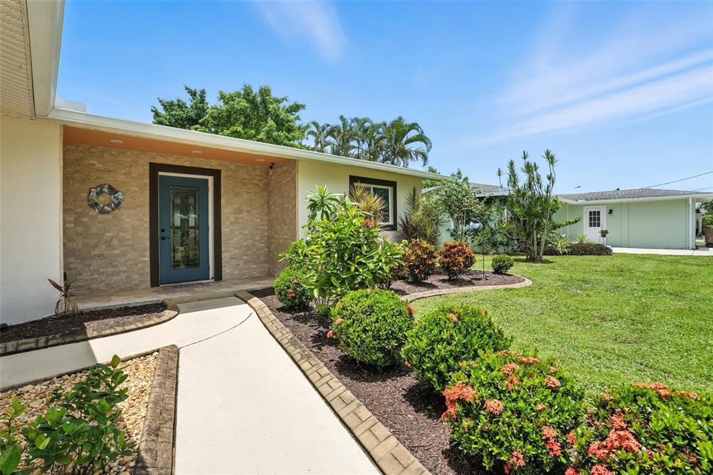 A front exterior view of a house with a blue door and stone facade — 2131 SAINT CROIX AVENUE, FORT MYERS, FL