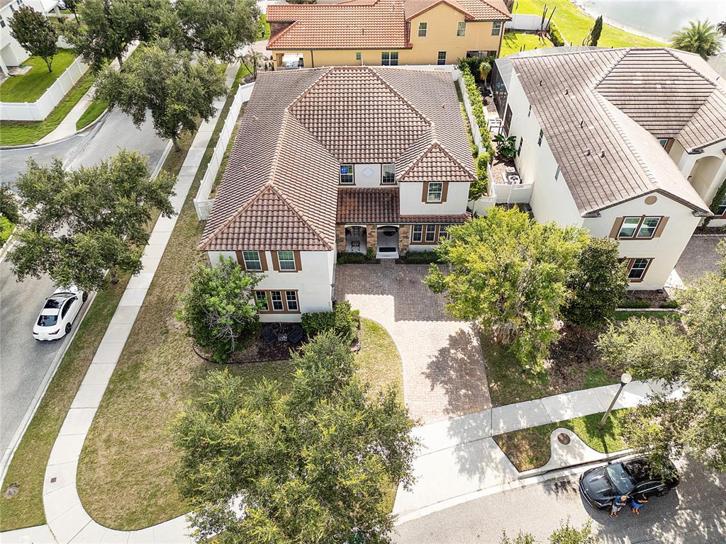 An aerial view shows a single-story house with a tiled roof, driveway, and fenced yard — 6152 GOLDEN DEWDROP TRAIL, WINDERMERE, FL
