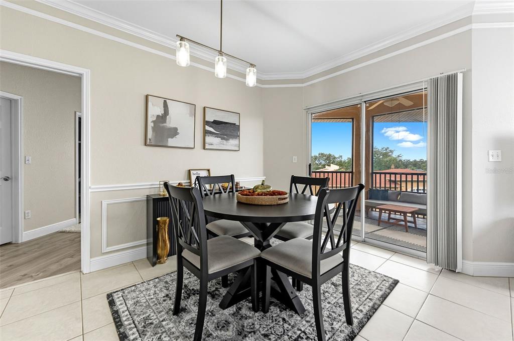 A dining room with a round table, four chairs, and a sliding door to a balcony — 4333 BAYSIDE VILLAGE DRIVE UNIT 304, TAMPA, FL