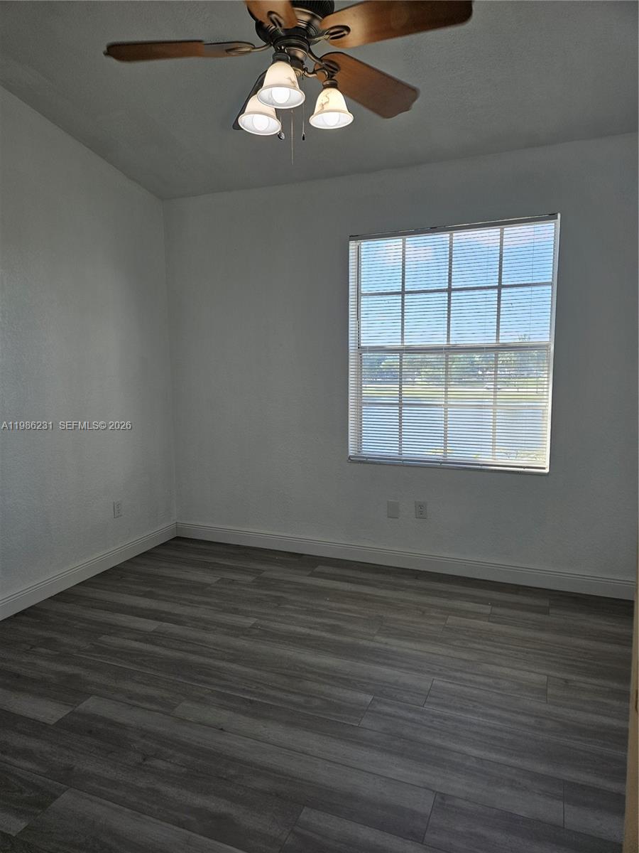 An empty bedroom features gray wood-look flooring, a ceiling fan, and a window with blinds — 751 SW 148th Ave # 1012, Sunrise FL 33325, SUNRISE, FL