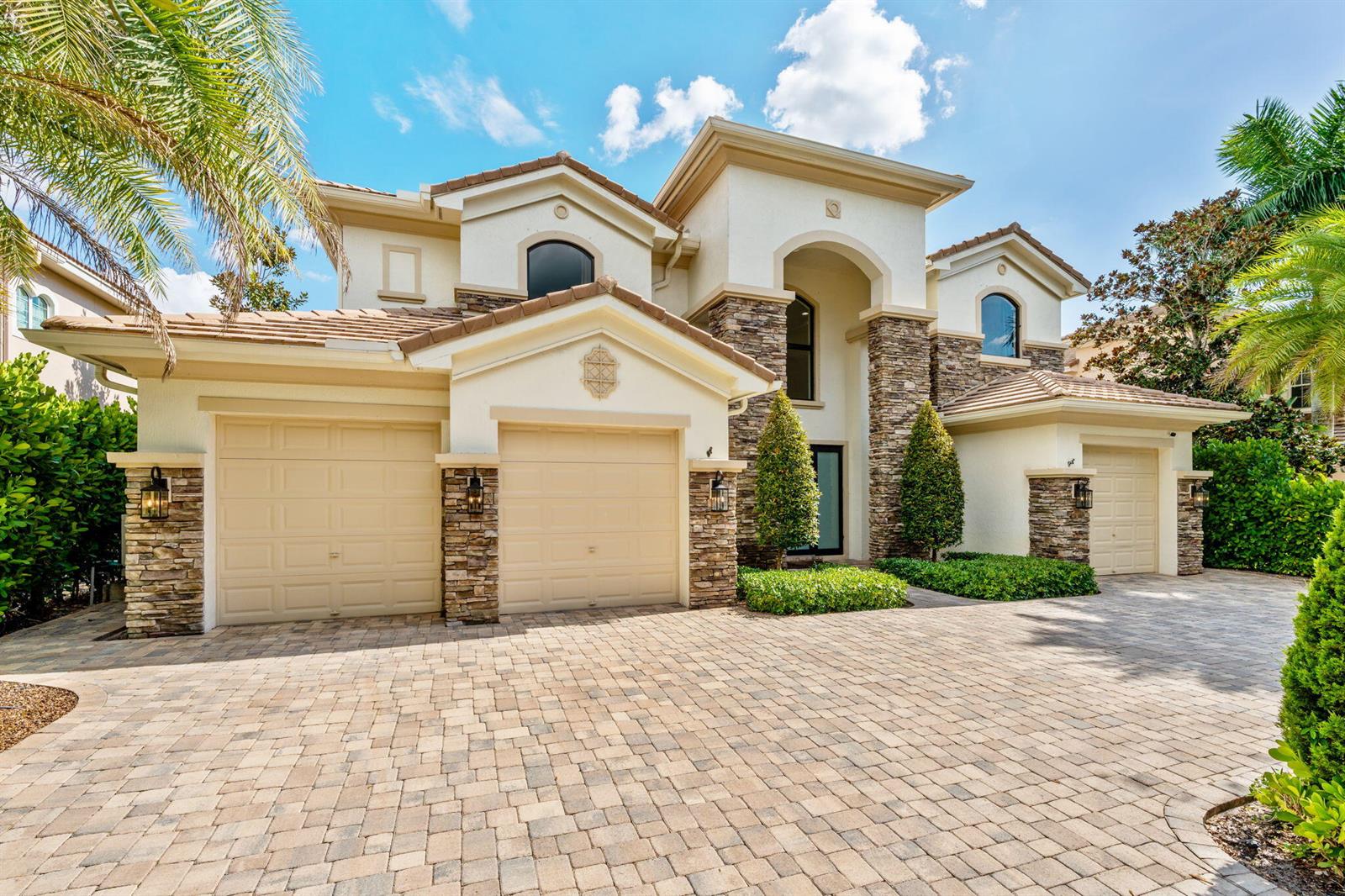 A two-story stucco and stone house with a three-car garage and paved driveway — 647 Edgebrook Lane, Royal Palm Beach FL 33411, ROYAL PALM BEACH, FL