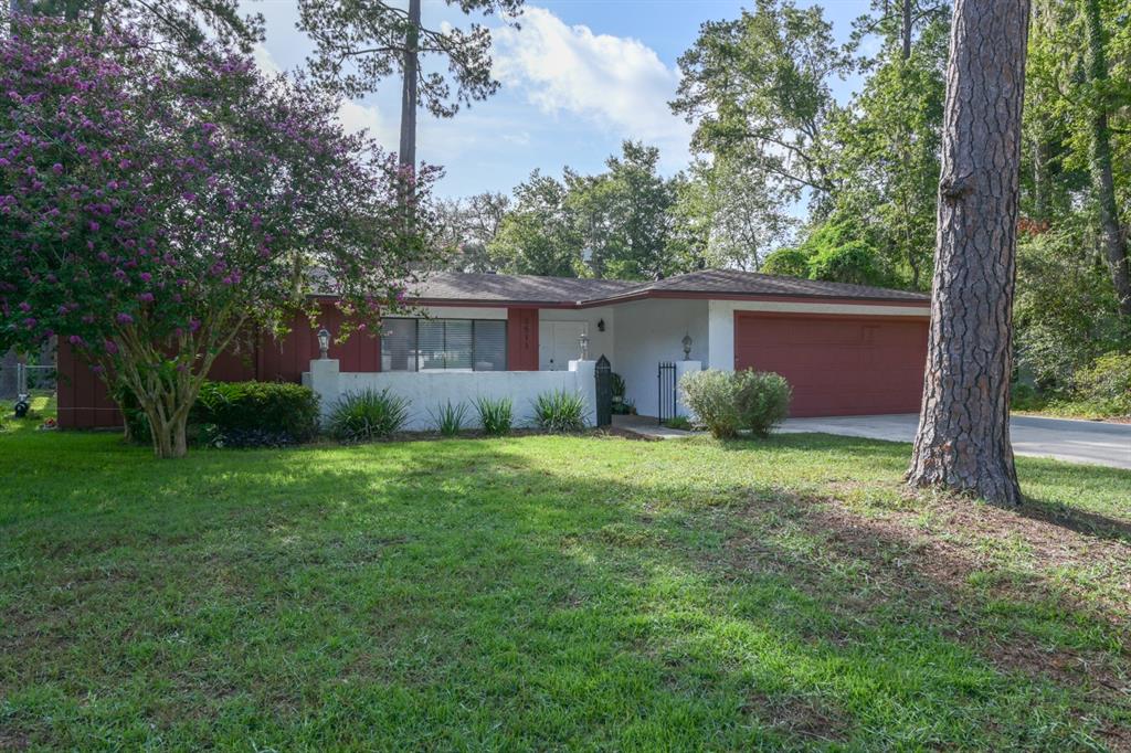 A single-story house with red siding, a white brick wall, and a two-car garage — 3511 NW 40TH TERRACE, GAINESVILLE, FL