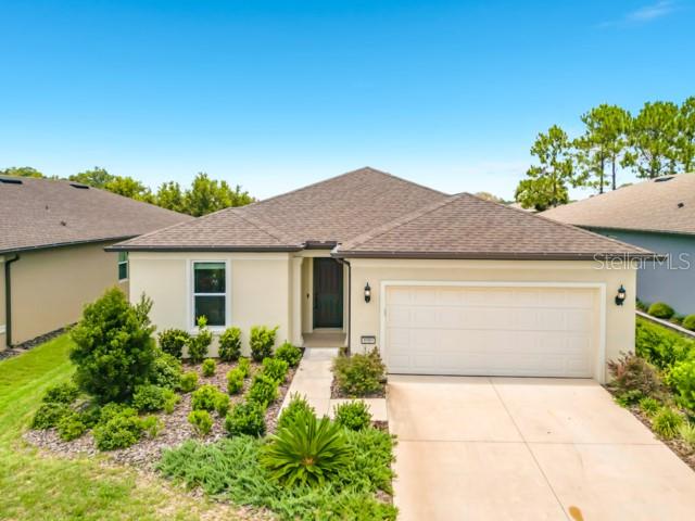 A single-story house with a beige exterior, a brown shingled roof, and a two-car garage — 8989 SW 57TH PLACE ROAD, OCALA, FL