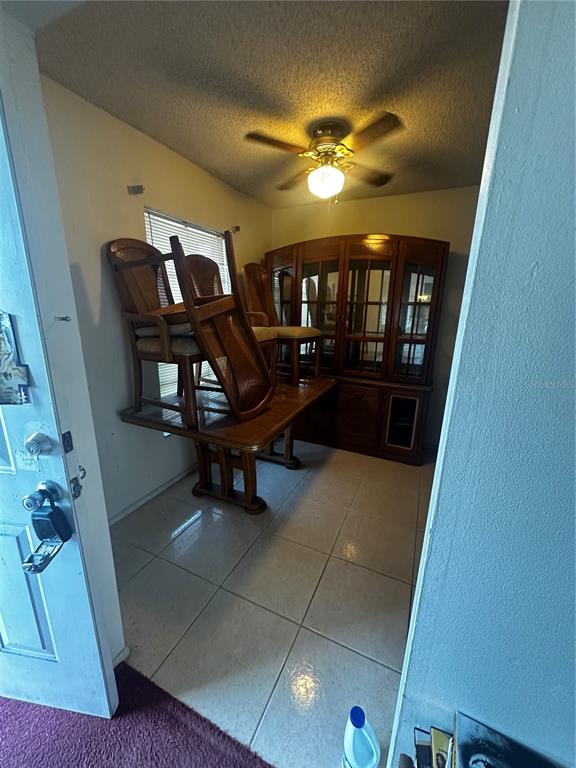 A dining room features tiled floors, a ceiling fan, a hutch, and stacked wooden chairs — 3350 E STATE ROAD 46, SANFORD, FL