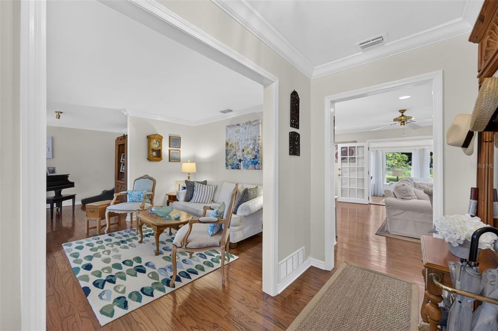 A view through a doorway into a living room with hardwood floors and area rugs — 823 WOODS COURT, MAITLAND, FL