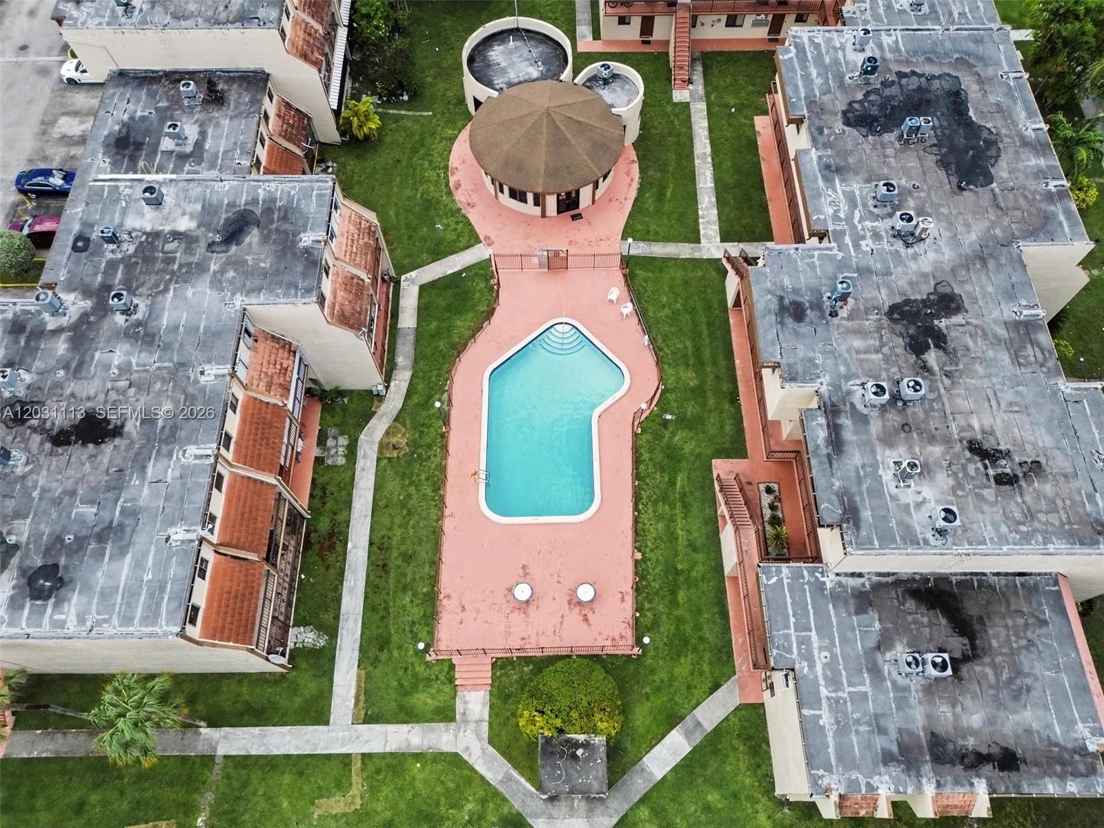 An aerial view shows a swimming pool and a gazebo between two apartment buildings — 1001 SW 105 Ave # 113, Miami FL 33174, MIAMI, FL