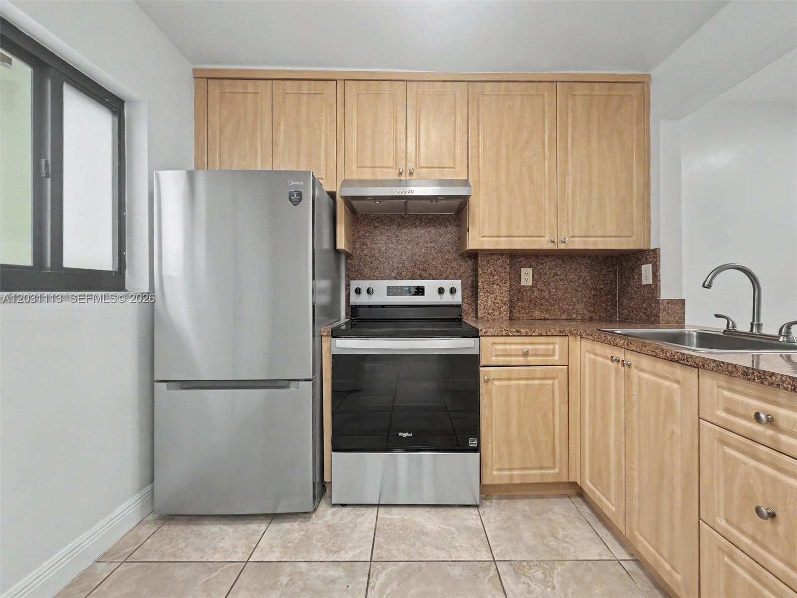 A kitchen features light wood cabinets, stainless steel appliances, and brown granite countertops — 1001 SW 105 Ave # 113, Miami FL 33174, MIAMI, FL
