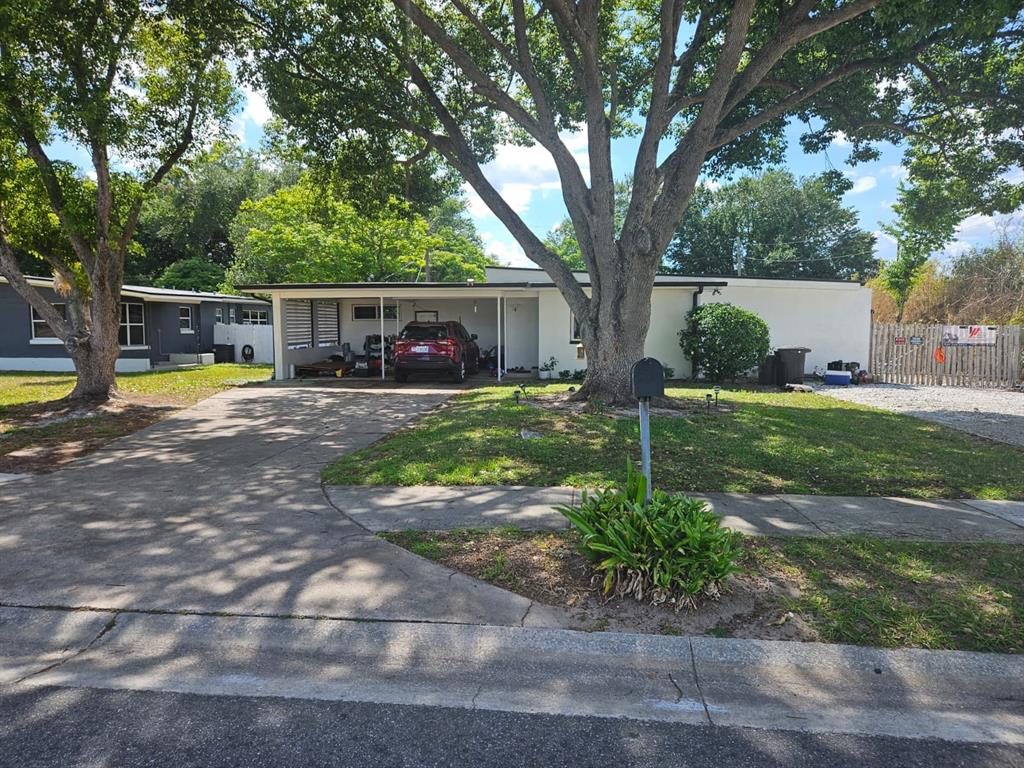 A single-story house with a carport, a large tree in the front yard, and driveway — 2800 S FRENCH AVENUE, SANFORD, FL
