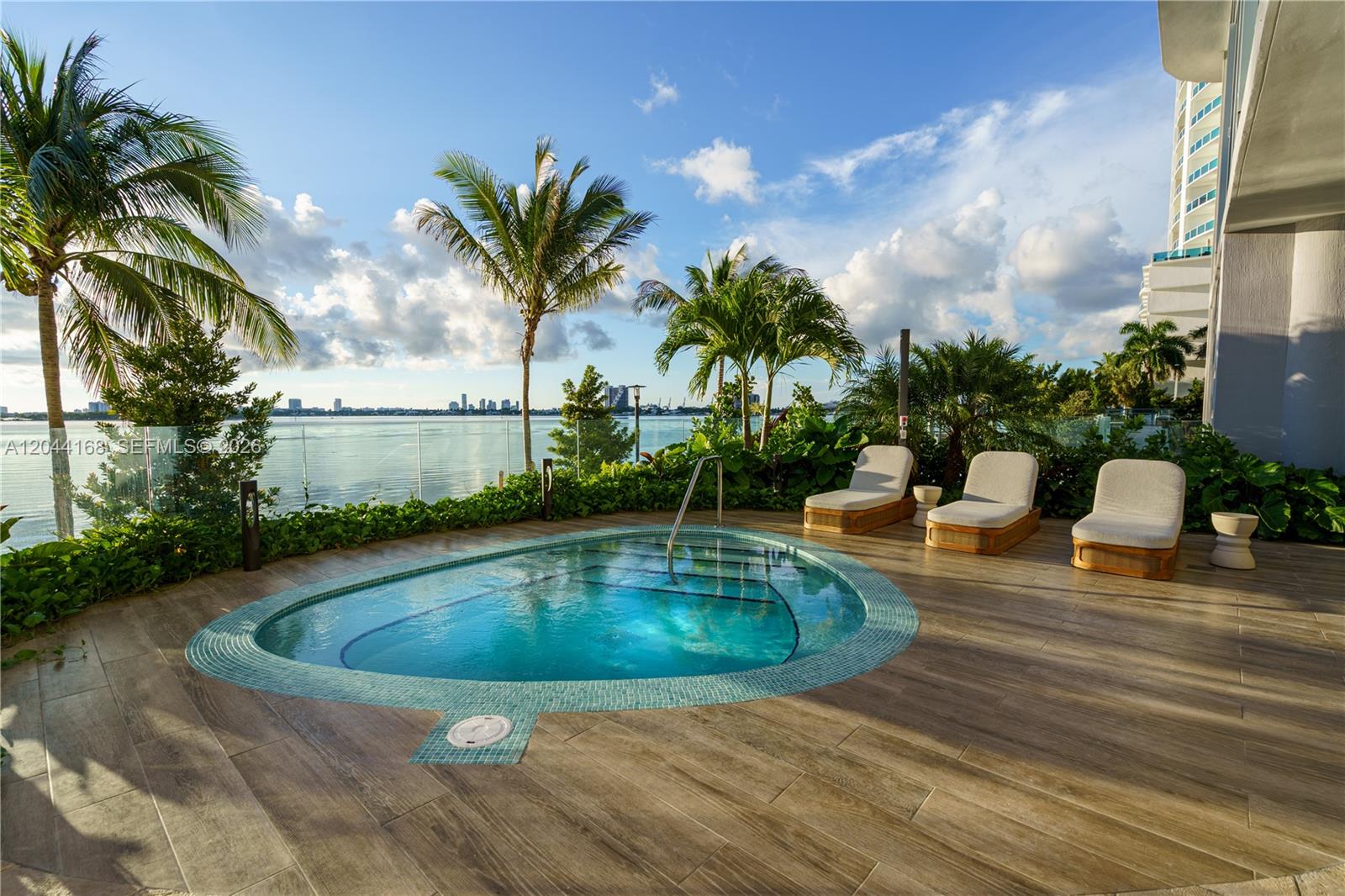 A patio features a small pool, three lounge chairs, and a view of the water — 700 NE 23rd St # 2304, Miami FL 33137, MIAMI, FL