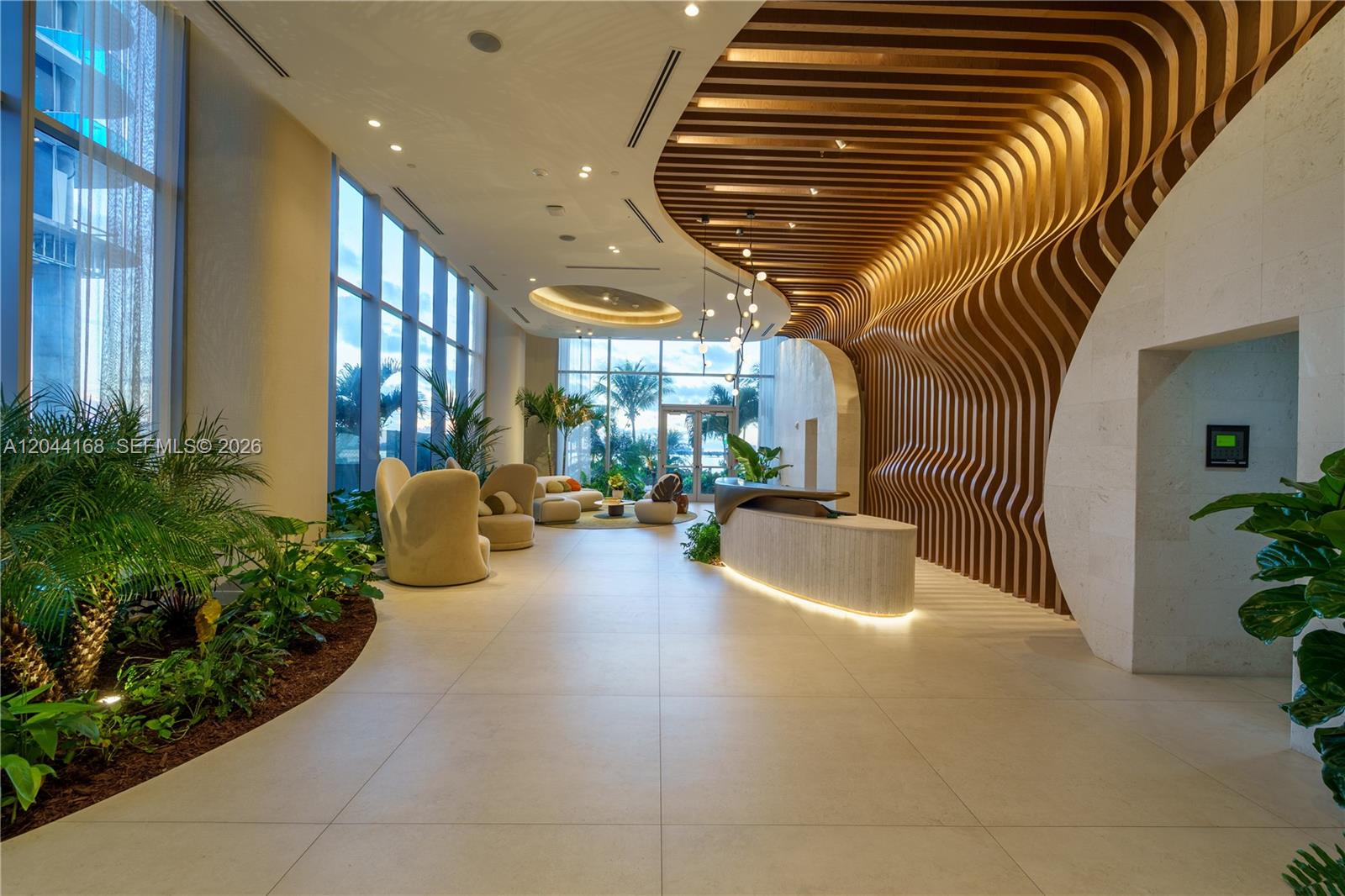 A modern lobby features a curved wood-slat ceiling, a reception desk, and floor-to-ceiling windows — 700 NE 23rd St # 2304, Miami FL 33137, MIAMI, FL