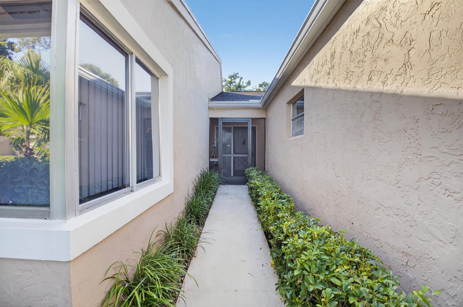 A concrete walkway leads to a screened front entryway between two stucco exterior walls — 8256 Summerbreeze Lane, Boca Raton FL 33496, BOCA RATON, FL