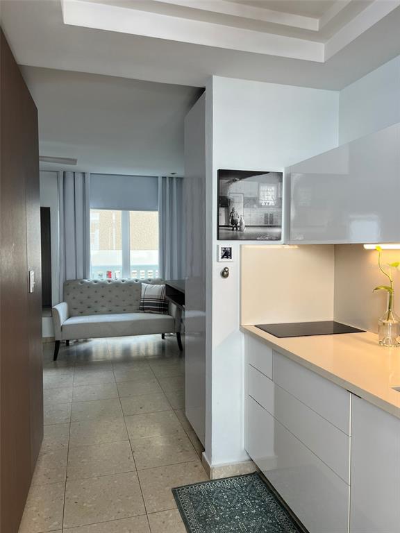 A view from a modern kitchen with white cabinetry looking toward a living area — 3511 ISLA VERDE AVE UNIT 204, CAROLINA, PR