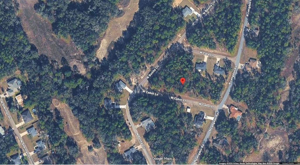 This is a satellite map view of a wooded residential lot marked with a red pin — 447 W CABOT LANE, DUNNELLON, FL