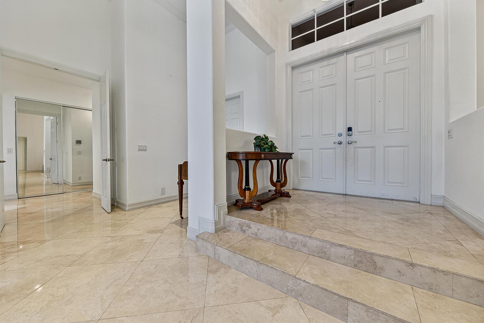 A tiled entryway features a two-step elevation, a wooden console table, and double front doors — 7233 NW 123rd Avenue, Parkland FL 33076, PARKLAND, FL