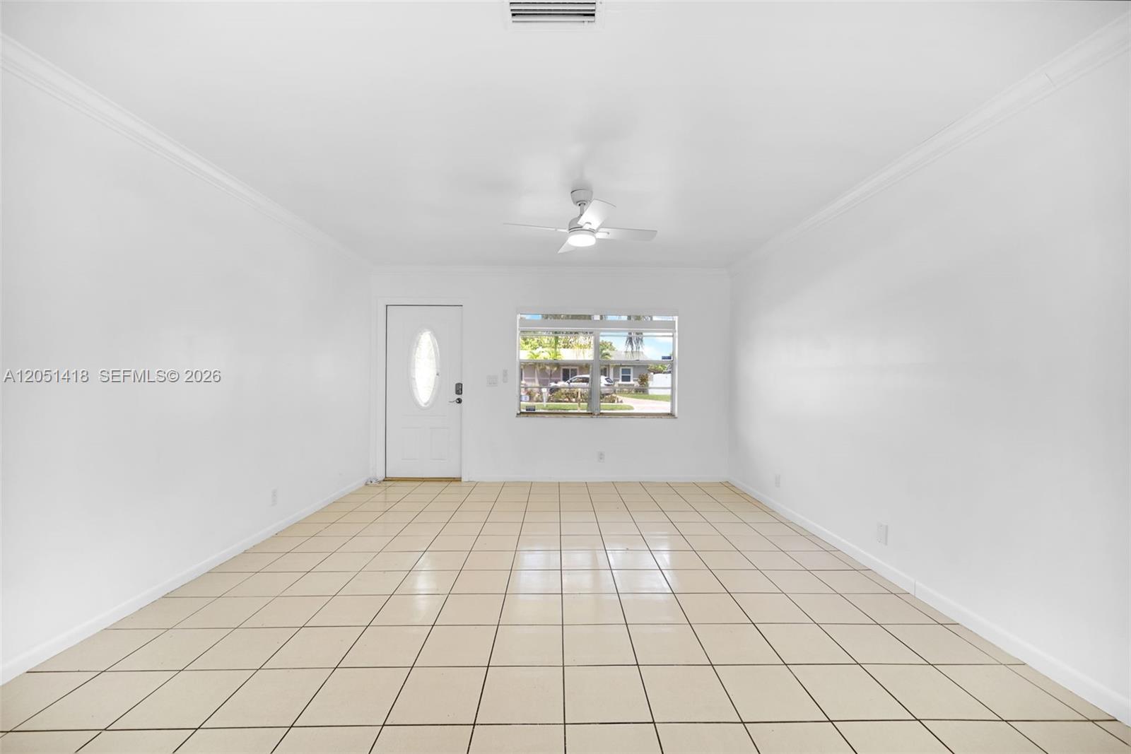 A bright, empty room features white walls, beige tile flooring, a ceiling fan, and a window — 304 SW 77th Ave, North Lauderdale FL 33068, NORTH LAUDERDALE, FL