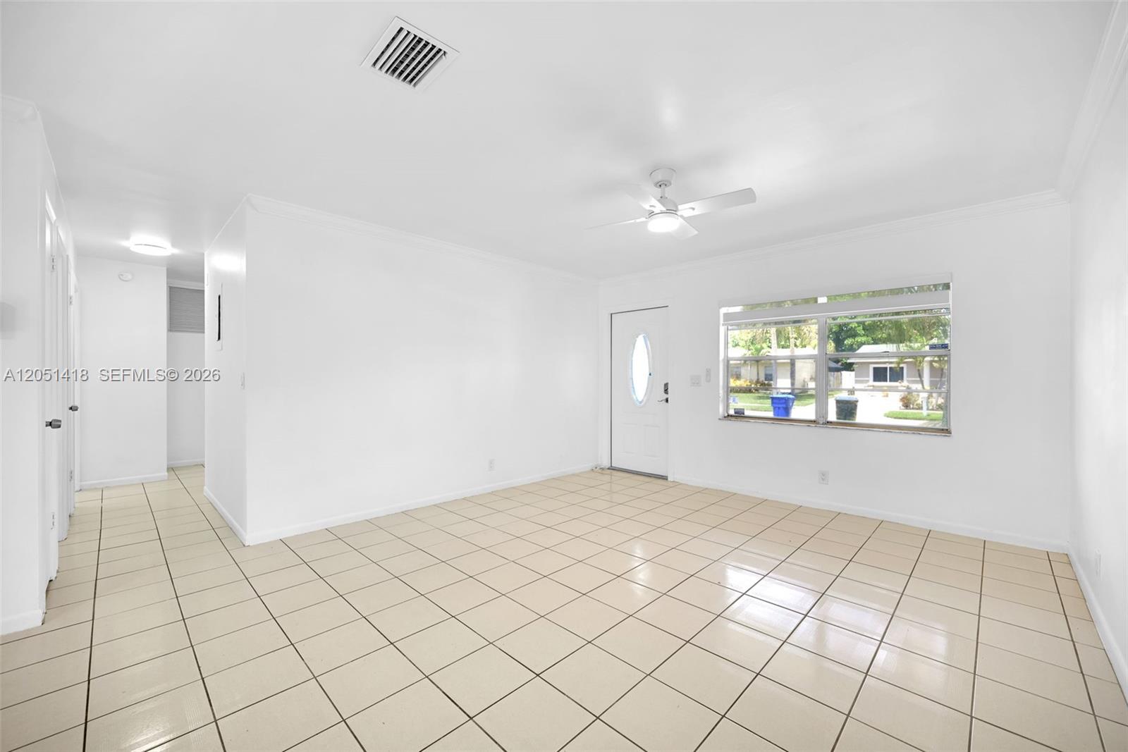 A bright, empty room features white walls, beige tile flooring, a ceiling fan, and a window — 304 SW 77th Ave, North Lauderdale FL 33068, NORTH LAUDERDALE, FL