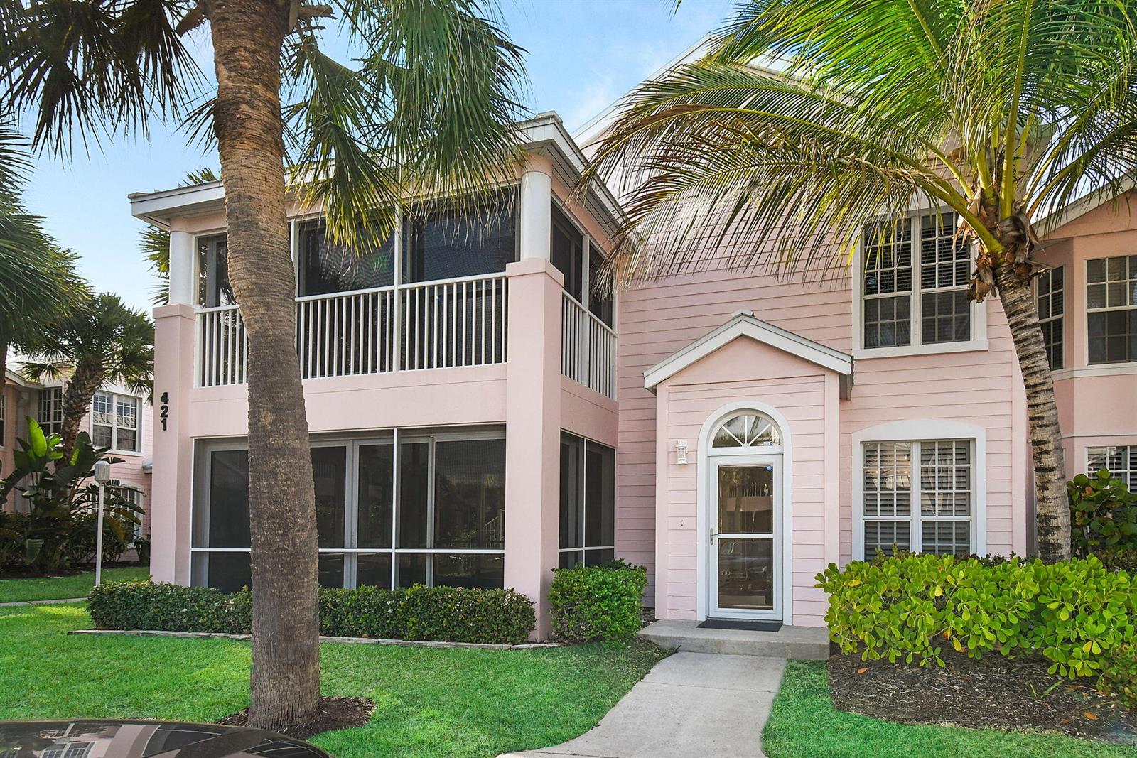 A two-story pink building features screened-in porches, white railings, and a front entryway — 421 NE Plantation # 617, Stuart FL 34996, STUART, FL
