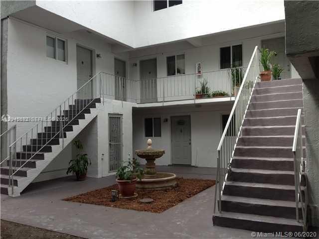 An exterior courtyard features a central fountain, potted plants, and two sets of concrete stairs — 7626 NE 6th Ct # 5, Miami FL 33138, MIAMI, FL