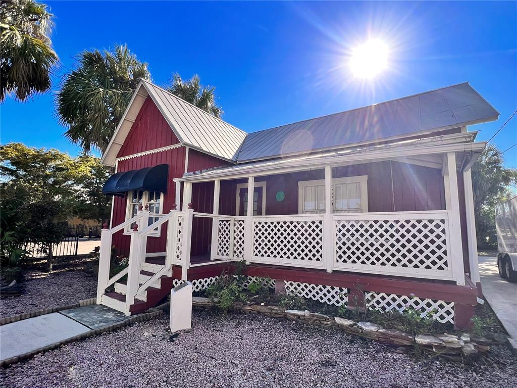 A red wooden house with a metal roof and a white lattice porch — 225 SULLIVAN STREET, PUNTA GORDA, FL