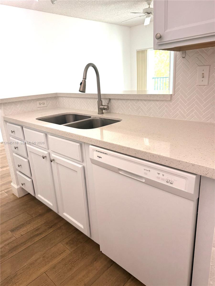 An open-concept living area features wood-look tile flooring, a kitchen island, and a balcony — 6001 SW 70th St # 355, South Miami FL 33143, SOUTH MIAMI, FL