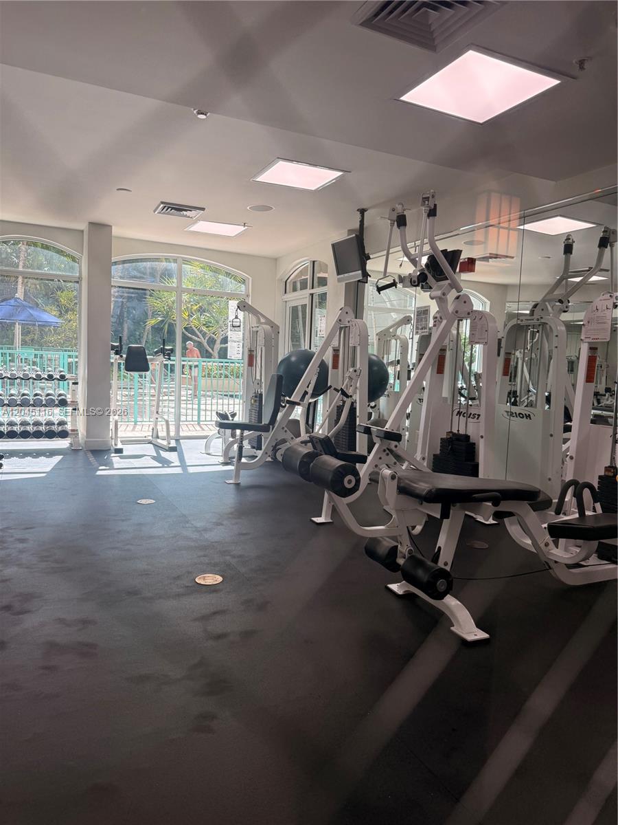 A living room features a grey sofa, a coffee table, and a sliding glass balcony door — 6001 SW 70th St # 355, South Miami FL 33143, SOUTH MIAMI, FL