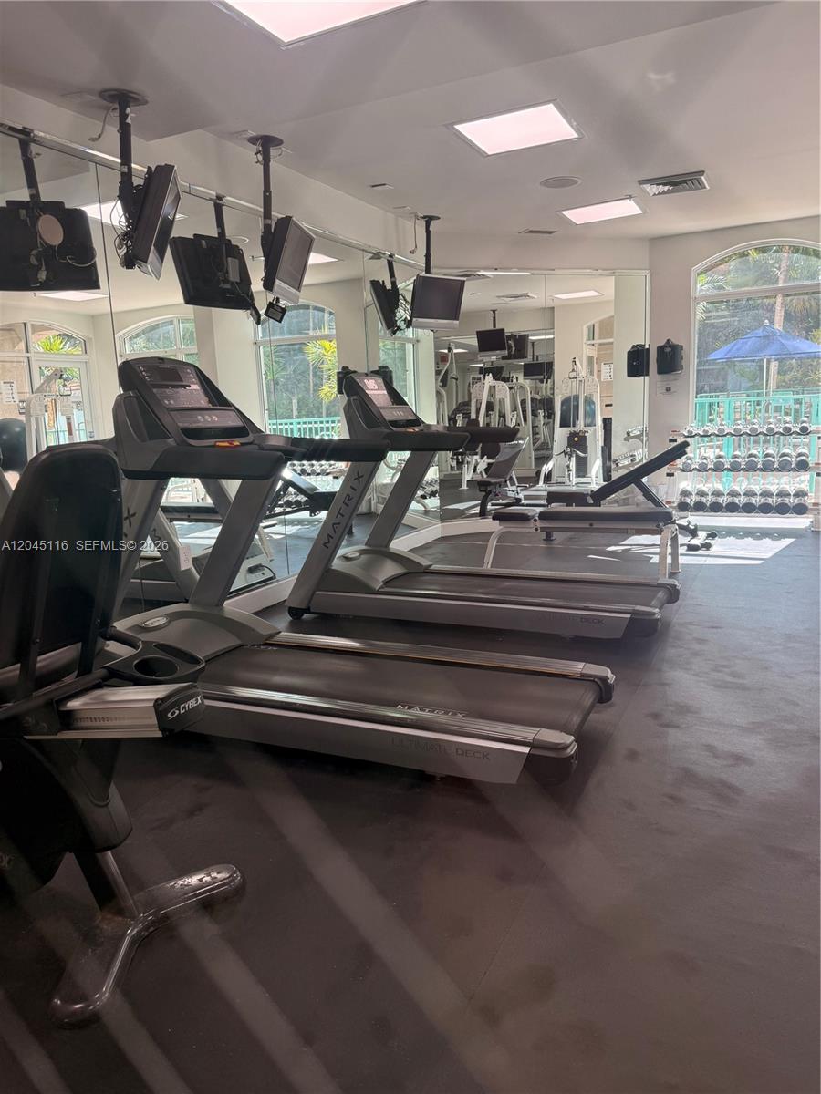 A small kitchen features white cabinets, white appliances, a double sink, and track lighting — 6001 SW 70th St # 355, South Miami FL 33143, SOUTH MIAMI, FL
