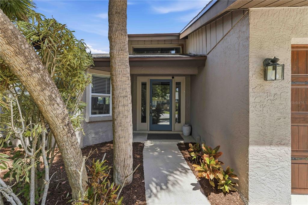 The exterior view shows a front entrance with a blue door, walkway, and landscaping — 3953 PRAIRIE DUNES DRIVE, SARASOTA, FL