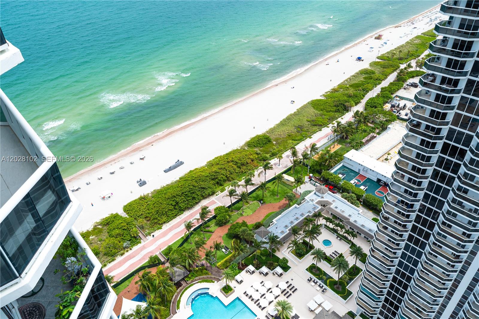 An aerial view shows a high-rise balcony overlooking a beach, ocean, and pool area — 4779 Collins Ave # 3504, Miami Beach FL 33140, MIAMI BEACH, FL