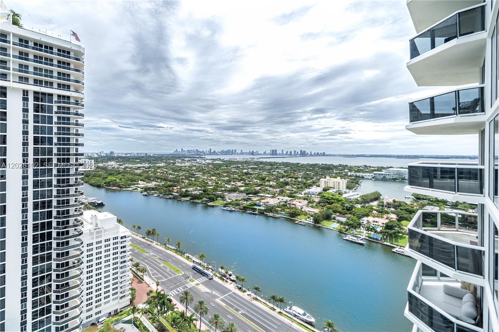 A high-angle view shows a waterway, a road, and high-rise buildings under a cloudy sky — 4779 Collins Ave # 3504, Miami Beach FL 33140, MIAMI BEACH, FL