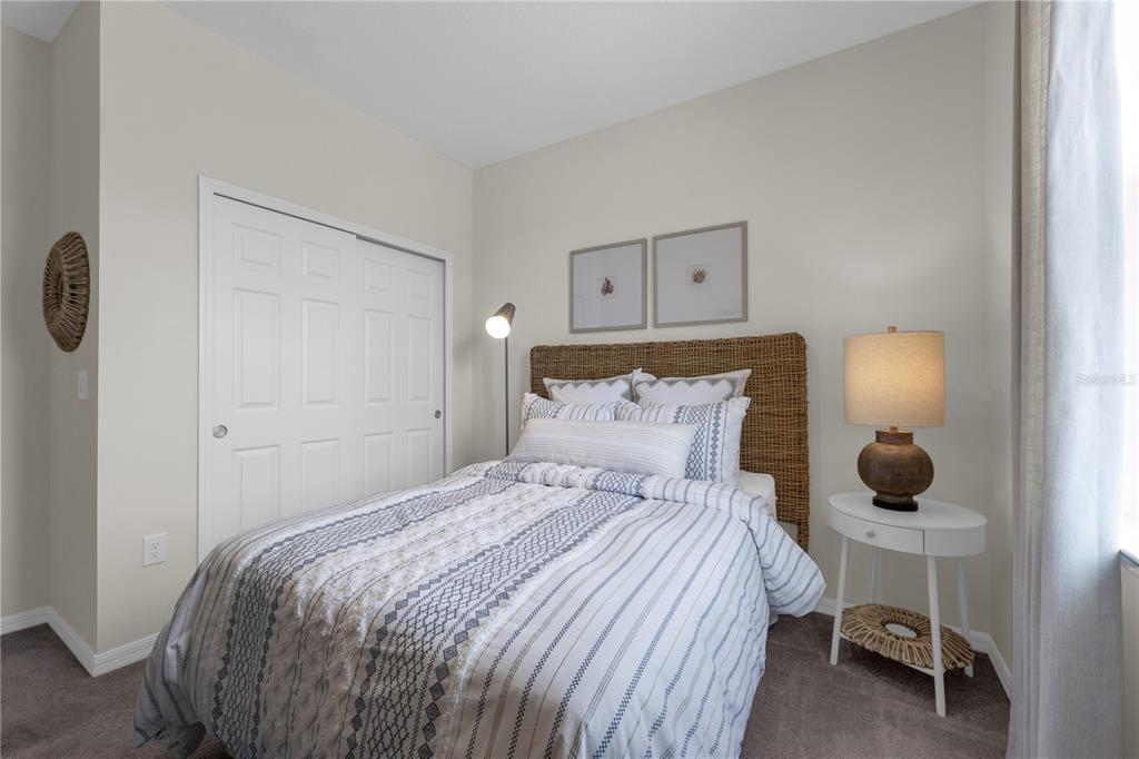 A bedroom features a bed with a woven headboard, a white nightstand, and a closet — 6767 WINTERBERRY DRIVE, LAKE HAMILTON, FL