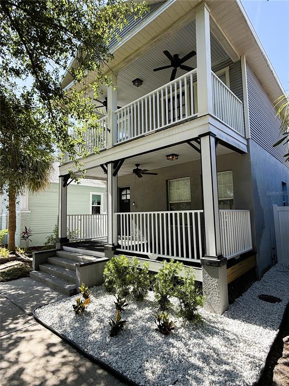 A two-story house features a covered front porch and a second-floor balcony with white railings — 1934 W SPRUCE STREET, TAMPA, FL